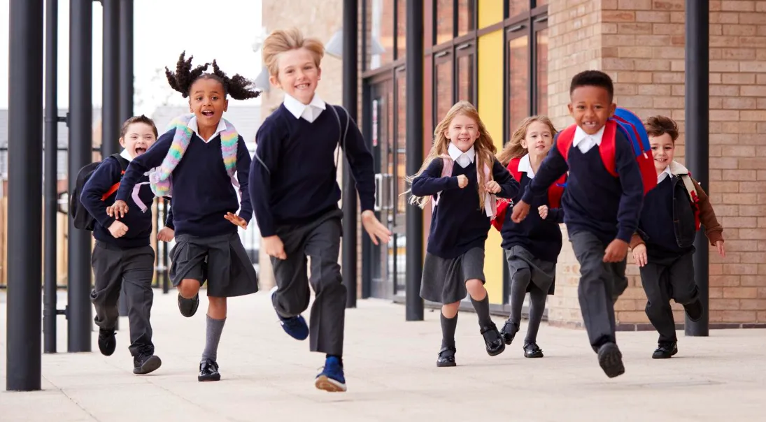 Excited primary school children running